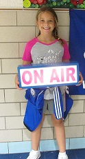 student holding "on air" sign